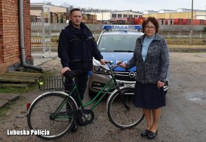 policjant i mieszkanka przy rowerze.