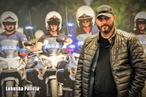 Policjant po cywilnemu na tle fototapety z policyjnymi motocyklami