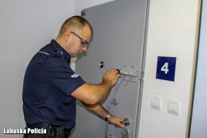 Policjant zamyka pomieszczenie dla osób zatrzymanych