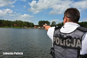 Policjant z patrolu wodnego monitoruje sytuacje nad wodą