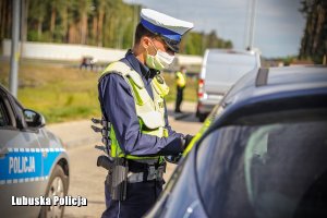 Policjant ruchu drogowego kontrolujący auto