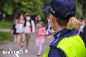 policjantka przygląda się dzieciom idącym do szkoły
