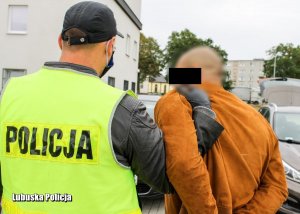 Policjant z zatrzymanym mężczyzną.