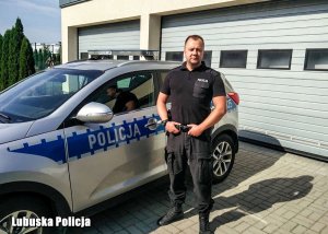 policjant stoi przy radiowozie