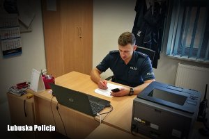 policjant, młodszy aspirant Piotr Kruk siedzi w gabinecie