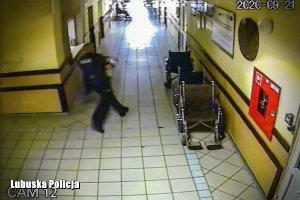 Policjant z dzieckiem na rękach biegnie po szpitalnym korytarzu
