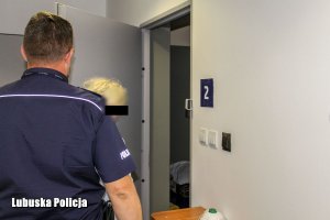 policjant osadza podejrzaną w areszcie