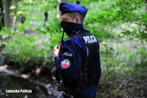 Policjant oddziałów prewencji podczas poszukiwań w lesie.