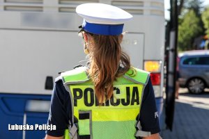 Policjantka kontrolująca prawidłowość oświetlenia autokaru