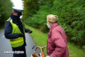 Policjant przekazuje odblask rowerzystce