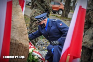 Komendant Wojewódzki Policji składający wiązankę kwiatów.