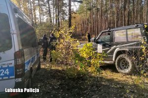 radiowóz i funkcjonariusze w lesie