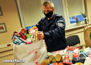 Policjant przy zbiórce produktów dla potrzebujących