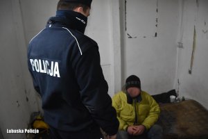Policjant  sprawdzający osoby bezdomne w opuszczonym budynku