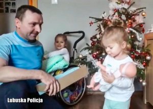 Dziewczynka otwiera prezent od policjantów