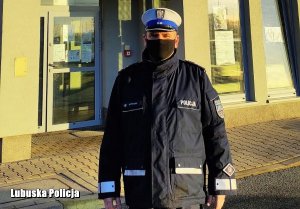 policjant stoi przed budynkiem