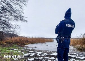 Policjant sprawdzający czy na zamarzniętym jeziorze nie ma osób.