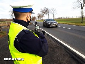 Policjant z miernikiem prędkości przy drodze