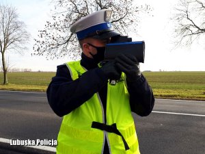 Policjant z miernikiem prędkości mierzy prędkość kierowców