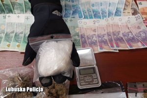 policjant trzyma woreczek z narkotykami