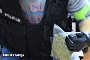 policjant trzyma zabezpieczone narkotyki