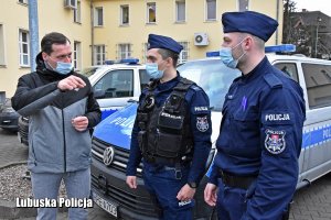 Mężczyzna rozmawia z dwójką policjantów.