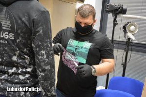technik kryminalistyki przygotowuje się do pobrania wymazu od podejrzanego