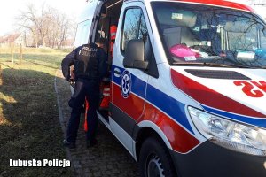 policjant stoi przy karetce