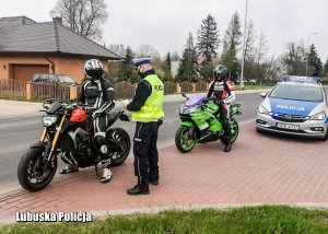 Policjant przeprowadza kontrolę drogową motocyklisty.