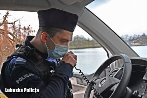 policjant podaje komunikat przez radiostację