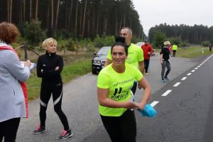 kobieta w stroju sportowym biegnie