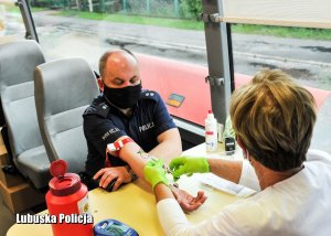 Policjant oddający próbkę krwi do badań