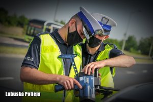 policjanci regulują urządzenie pomiarowe