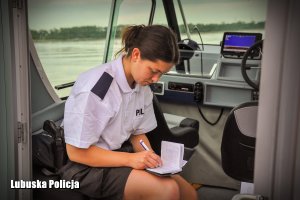 policjantka na łodzi pisze w notatniku