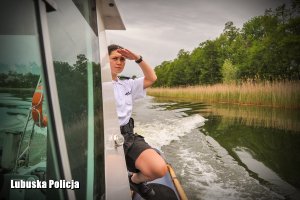 policjanta na łodzi obserwuje jezioro