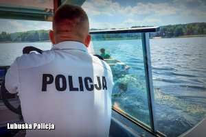 Widok policjanta w policyjnej motorówce. Kontrola osoby w łodzi