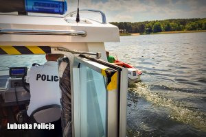 Widok policjanta w policyjnej motorówce. Kontrola łodzi