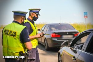 policjanci ruchu drogowego prowadzą kontrole pojazdu