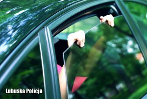 Palce dziewczynki trzymają uchylona szybę w samochodzie