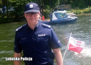 Zastępca Komendanta Wojewódzkiego Policji w Gorzowie Wielkopolskim przy jeziorze. W tle policyjna motorówka