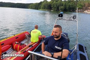 policjant z ratownikiem siedzą na łodziach