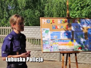 policjantka stoi obok tablicy z pracami dzieci