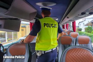 policjant idzie przez autobus