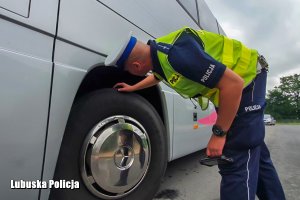 policjant sprawdza koła autokaru