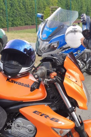 Pomarańczowy motocykle, a w tle motocykl policyjny.