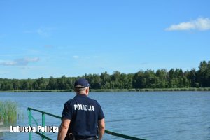 Policjant na pomoście nad jeziorem.