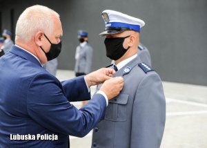 Wojewoda Lubuski przypina medal policjantowi.