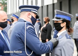Komendant Wojewódzki Policji przypina medal policjantce.