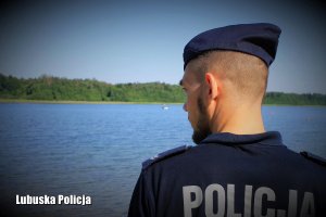 Policjant przy jeziorze sprawdza czy nikt nie potrzebuje pomocy