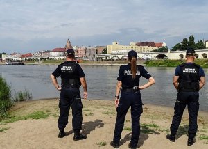 Policjantka i strażnicy miejscy podczas kontroli terenów przywodnych.